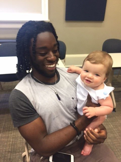 Grove Scholar holding baby